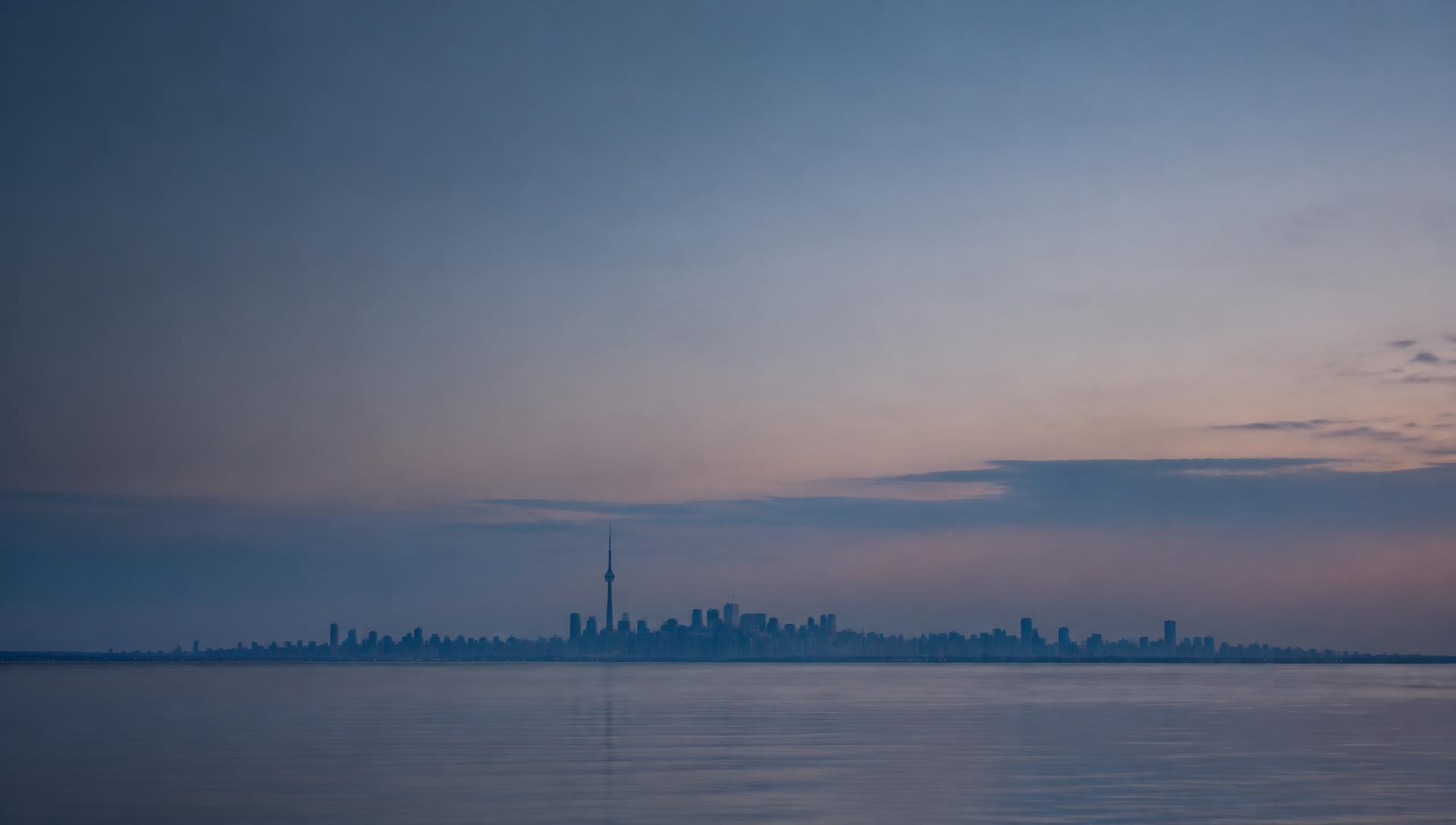 Toronto skyline across Lake Ontario at blue hour
